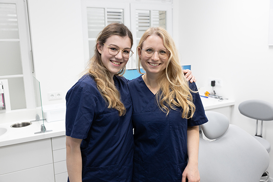 Zwei Oralchirurginnen stehen nebeneinander in einem Behandlungszimmer
